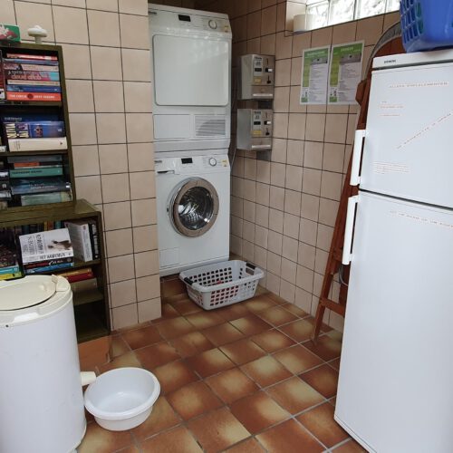 Een wasserette met een professionele wasmachine en droger, maar ook een losstaande centrifuge voor de handwasjes.